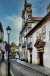 Iglesia o edificio histórico de Chaves visto desde una calle estrecha, con farola y arquitectura portuguesa.