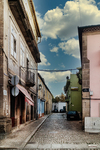 Calle empedrada de Chaves con casas antiguas, farolas y perspectiva hacia el centro histórico.