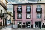Fachada rosa con balcones en el casco histórico de Chaves, Portugal, bajo cielo azul.