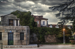 Casa antigua de piedra en Chaves, con jardín, árboles y cielo oscuro sobre el norte de Portugal.