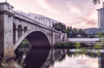 Puente de piedra sobre el río Támega en Chaves, con reflejos y cielo suave al atardecer.