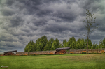 Campo abierto en Chaves, Portugal, con árboles, cielo de tormenta y paisaje rural.