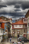 Calle del casco histórico de Chaves con casas de colores y cielo oscuro sobre Portugal.