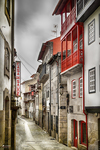 Calle estrecha de Chaves con fachada roja, paredes blancas y arquitectura tradicional portuguesa.