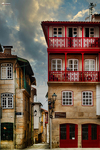 Edificio rojo con balcones acristalados en el casco histórico de Chaves, Portugal.