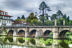 Puente romano de Chaves sobre el río Támega, con arcos de piedra y reflejos en el agua.