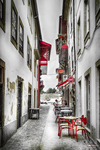 Calle estrecha de Chaves con mesas de terraza, fachadas blancas y ambiente del casco antiguo.