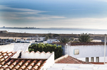 Vista panorámica de Lagos, Portugal, con casas blancas, tejados y el mar del Algarve al fondo.