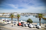Paseo junto al puerto de Lagos con palmeras, coches y vistas a la marina en la costa del Algarve.