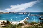 Playa turística de Lagos con hamacas, sombrillas, mar azul y cielo despejado.