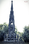 Monumento gótico en un parque de Praga rodeado de árboles.
