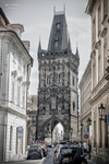 Torre de la Pólvora de Praga en blanco y negro entre edificios del casco antiguo.
