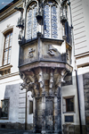 Detalle de balcón y fachada histórica ornamentada en una calle de Praga.