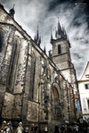 Iglesia gótica de Praga en blanco y negro vista desde una calle estrecha.