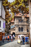 Torre histórica de Praga junto a una calle concurrida con luz de otoño.