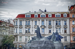 Edificio histórico de Praga con fuente o monumento en primer plano.