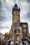 Torre medieval de Praga fotografiada en vertical con gente en la plaza.