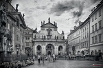 Plaza histórica de Praga en blanco y negro con iglesia y arquitectura clásica.