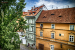 Fachadas de colores y tejados rojos en una calle tranquila de Praga.