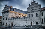 Palacio histórico de Praga con fachada clara y decoración geométrica.