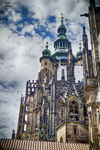 Iglesia monumental de Praga con torres y cúpulas bajo un cielo nublado.