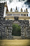 Puerta de piedra ornamentada en un jardín o palacio histórico de Praga.