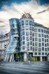 Casa Danzante de Praga con arquitectura contemporánea y cielo dramático.