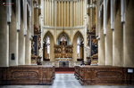 Interior de iglesia en Kutná Hora con órgano, bancos de madera y altar al fondo.