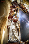 Escultura religiosa junto a un gran cuadro barroco en una iglesia de Kutná Hora.