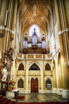 Interior de iglesia histórica en Kutná Hora con altar, órgano y arquitectura dorada.