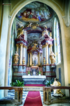 Capilla barroca con altar decorado, columnas y alfombra roja en Kutná Hora.