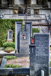 Lápida conmemorativa en un cementerio de Kutná Hora con flores y piedra negra.