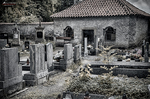 Cementerio antiguo de Kutná Hora en blanco y negro con lápidas y muro de piedra.