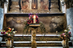 Altar con flores, velas y decoración religiosa en un interior histórico de Kutná Hora.