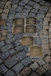 Adoquines con placas conmemorativas doradas en una calle de Kutná Hora.