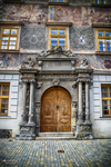 Puerta monumental de madera con decoración escultórica en un edificio de Kutná Hora.