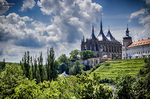 Catedral de Santa Bárbara en Kutná Hora vista desde una zona verde bajo cielo nublado.