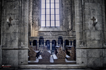 Interior de iglesia en Kutná Hora con bancos, columnas y luz entrando por la ventana.