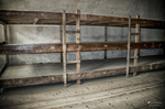 Dormitorio colectivo de Terezín con literas largas de madera.
