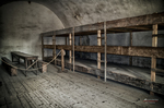 Dormitorio colectivo con estanterías y literas de madera en Terezín.
