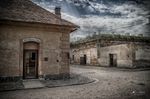Patio exterior de Terezín con edificios de ladrillo y suelo empedrado.