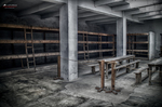 Sala colectiva del antiguo campo de Terezín con literas, mesas y columnas.