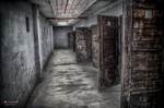 Pasillo interior deteriorado de Terezín con puertas y armarios antiguos.