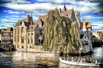 Canal de Brujas con sauces, casas de ladrillo y reflejos sobre el agua.