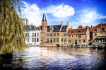 Vista del canal de Brujas con fachadas antiguas, tejados rojos y cielo azul.