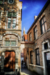Fachada histórica de Brujas con puerta ornamentada y arquitectura de piedra.