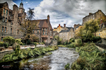 Vista de casas antiguas junto al río en un paisaje urbano de Escocia.