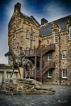 Patio histórico de piedra en Escocia con arquitectura antigua y cielo intenso.