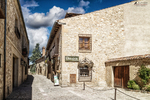 Plaza pequeña de Pedraza con casa de piedra y calle lateral.