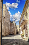 Calle empedrada de Pedraza con fachadas de piedra y cielo intenso.